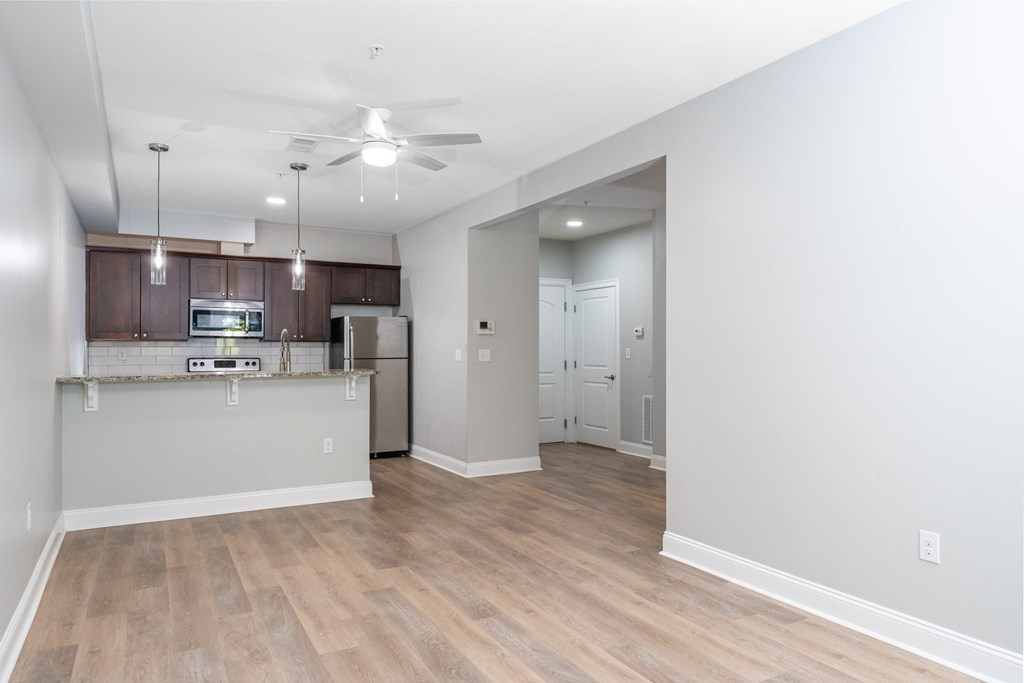 A kitchen with wooden floors and a ceiling fan.