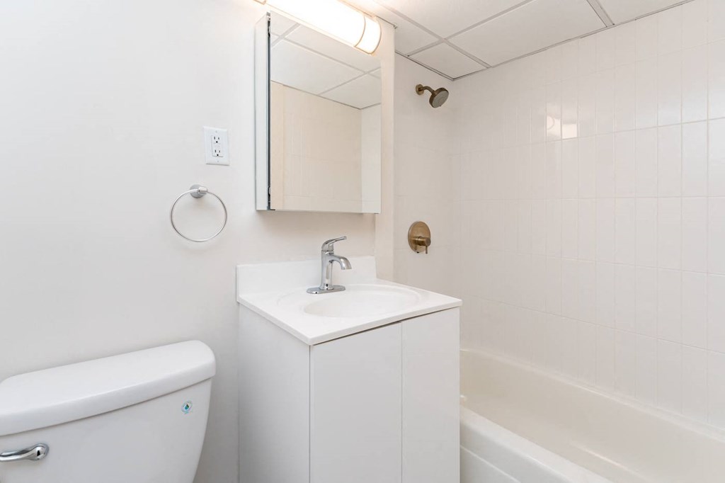 Babcock tower bathroom with bright finishes, large mirror and bathtub.