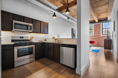 A kitchen with dark wood cabinets and a white stove top oven.