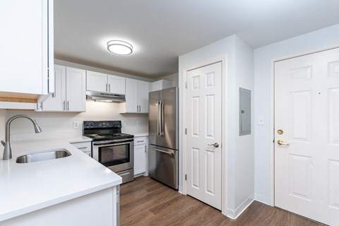 a renovated kitchen with white cabinets and stainless steel appliances
