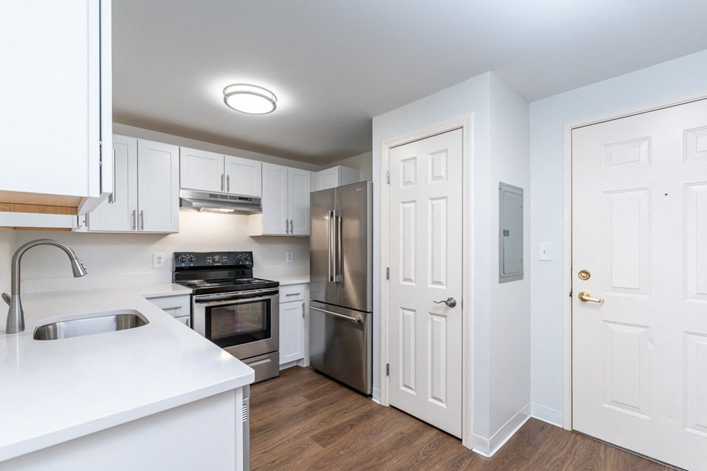 a renovated kitchen with white cabinets and stainless steel appliances
