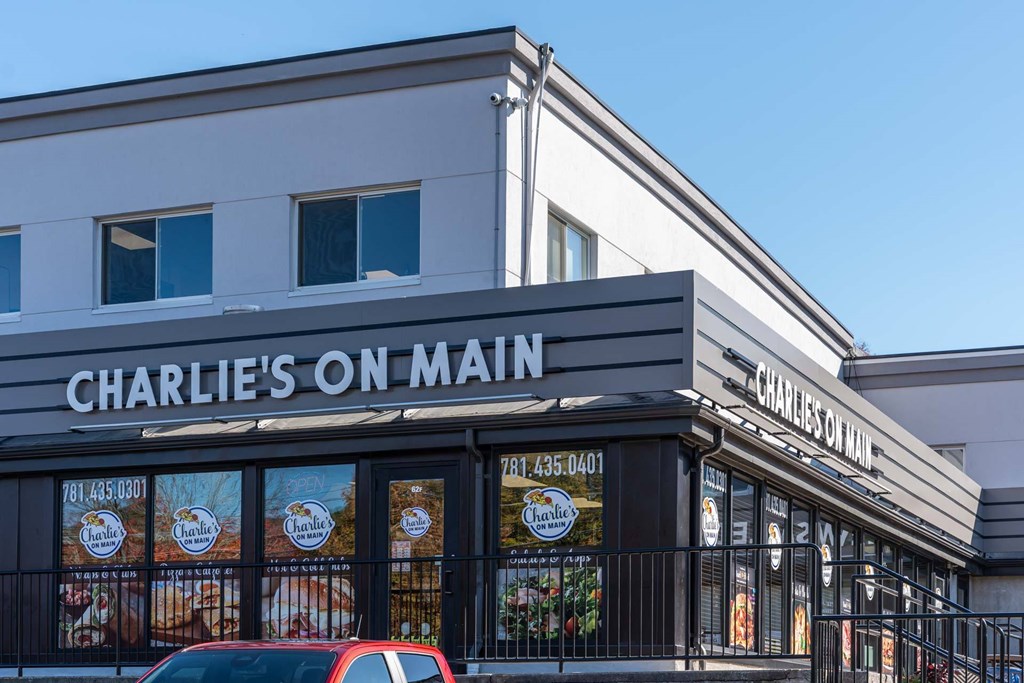 A Charlie's On Main restaurant with a red car parked in front.