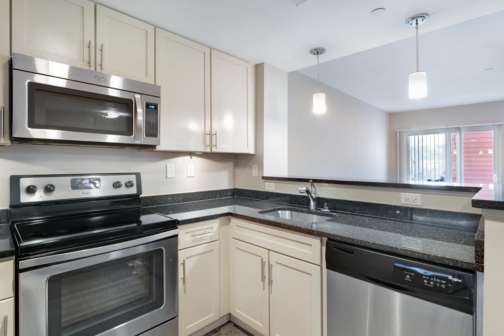 A kitchen with a stainless steel oven and microwave.