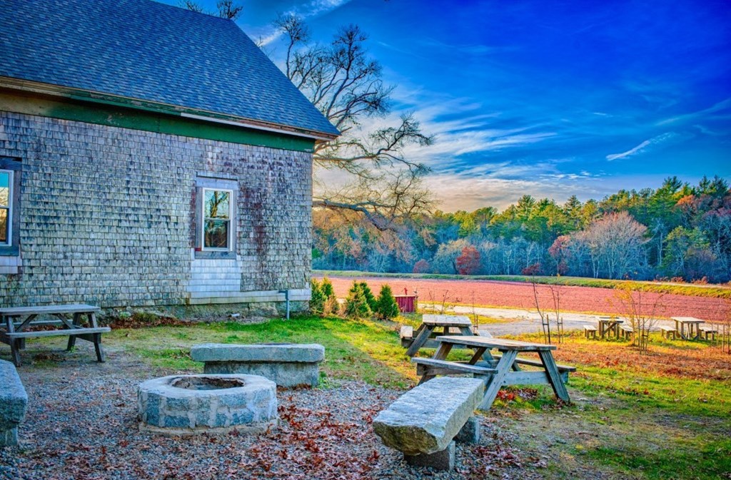 a group of picnic tables in front of a brick building