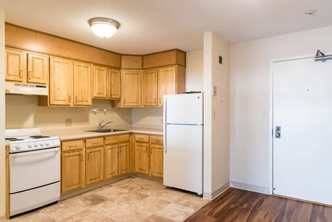 A kitchen with wooden cabinets and a white refrigerator.