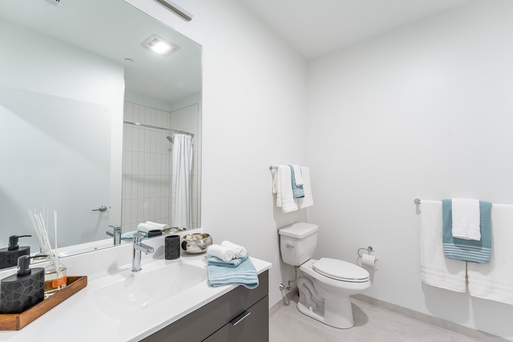 Studio apartment bathroom with large vanity and bright finishes