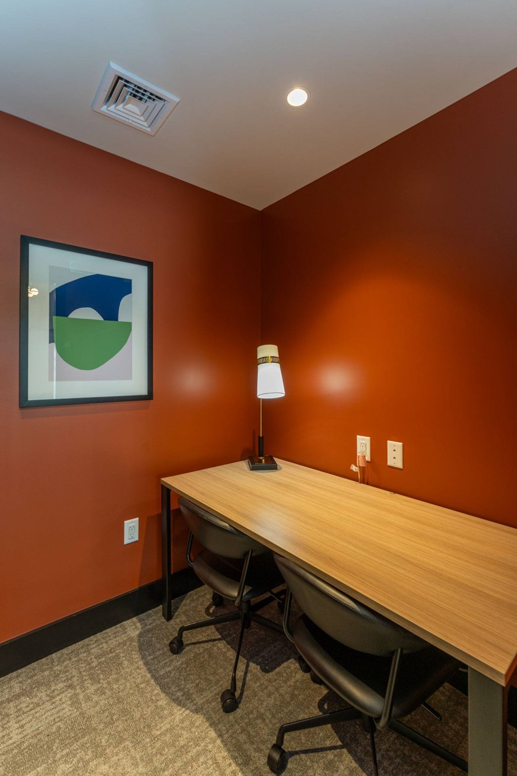 Private workspace with desk, chairs and lamp at The Devon at Weiss Farm apartments in Stoneham, MA.