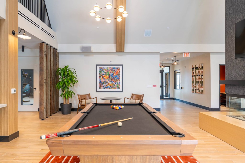 Elegant game lounge with pool table and seating at The Devon at Weiss Farm apartments in Stoneham, MA.