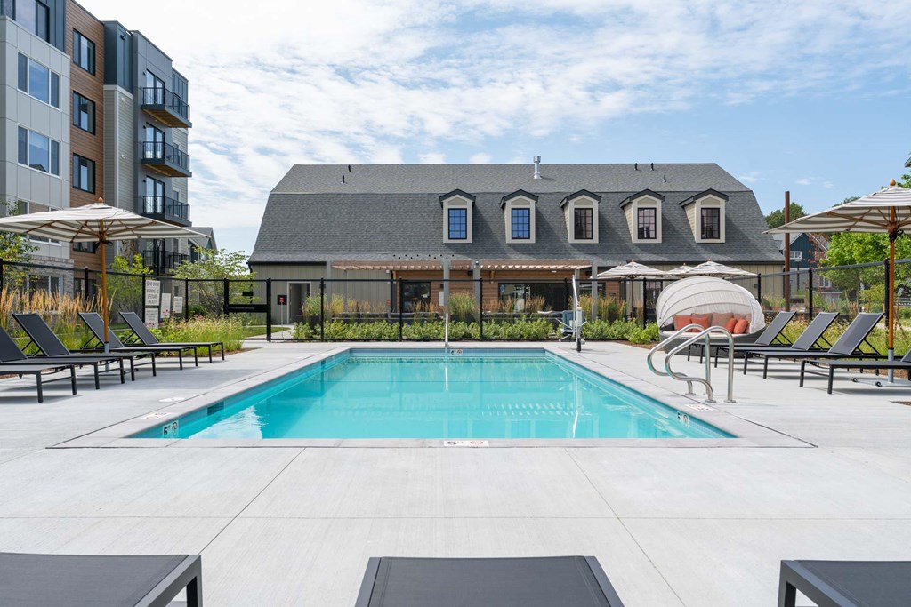 Resort-style pool with sun loungers at The Devon at Weiss Farm apartments in Stoneham, MA.