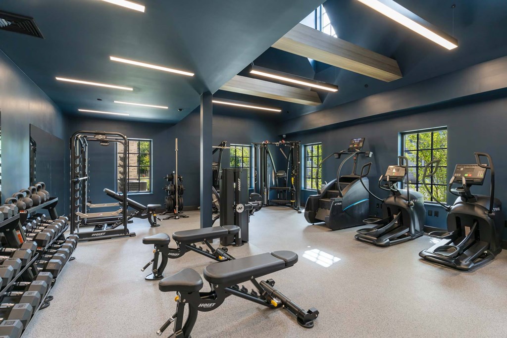 Fully equipped fitness center at The Devon at Weiss Farm in Stoneham, MA with free weights, benches and cardio machines.
