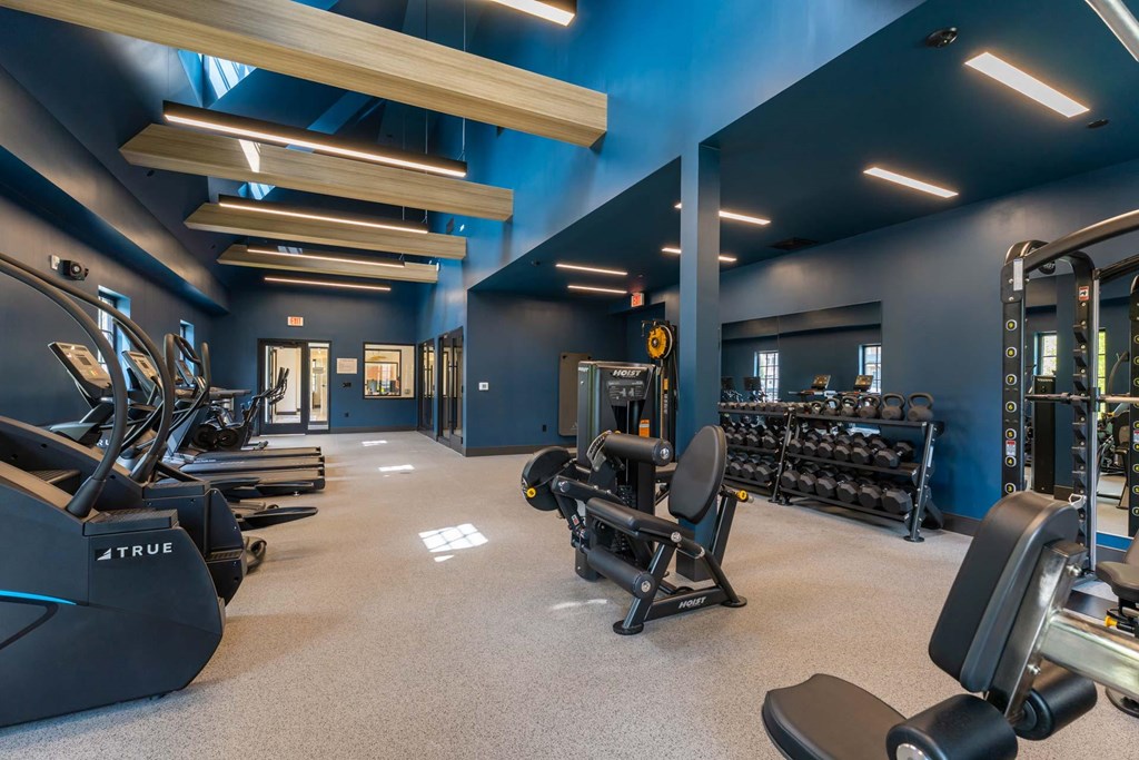 Spacious fitness center with cardio equipment and weight machines at The Devon at Weiss Farm in Stoneham, MA.