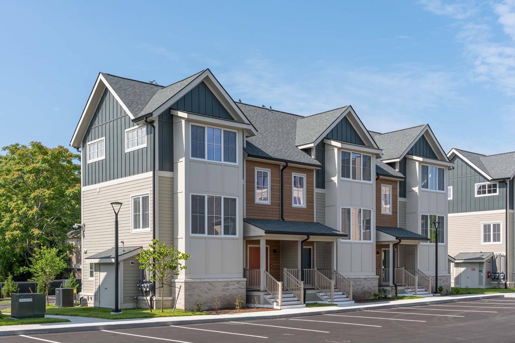 Townhome-style apartment exteriors at The Devon at Weiss Farm in Stoneham, MA with gabled roofs and porches.