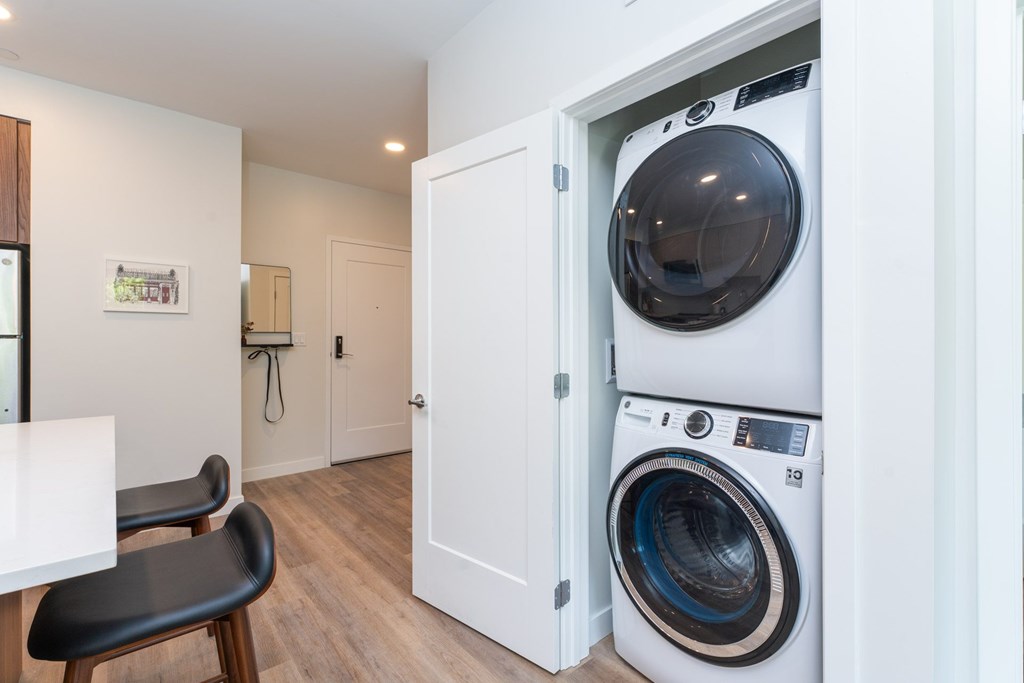 In-apartment stacked washer and dryer at The Devon at Weiss Farm in Stoneham, MA for resident convenience.