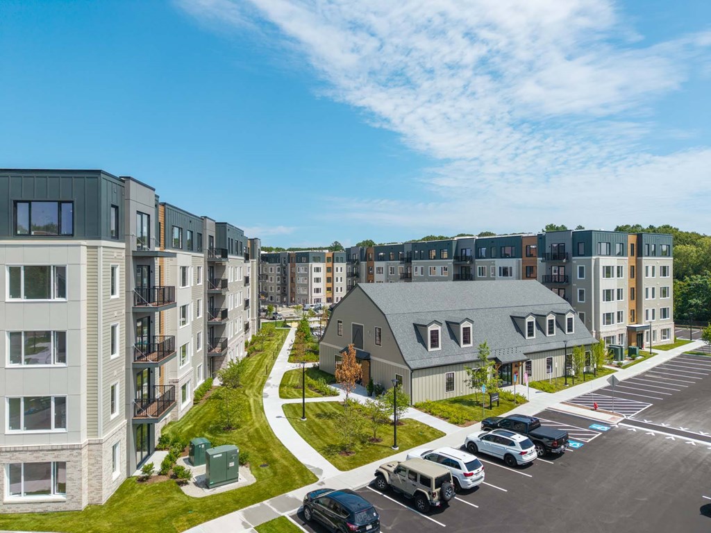 Aerial view of The Devon at Weiss Farm apartments in Stoneham, MA showing clubhouse, landscaped paths and parking.