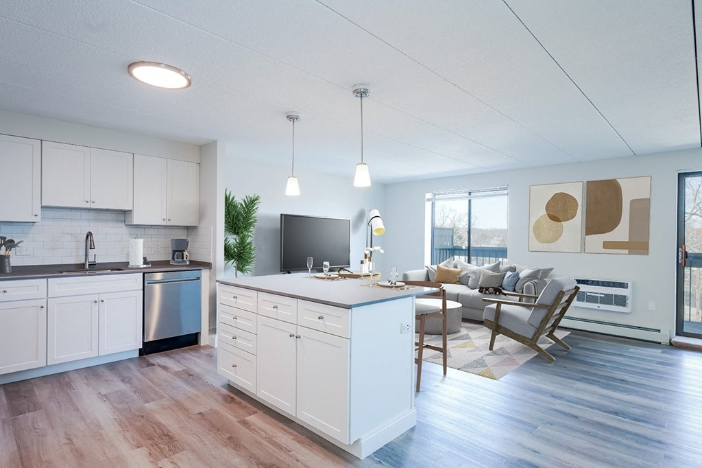 a kitchen and living room with hardwood floors and white cabinets