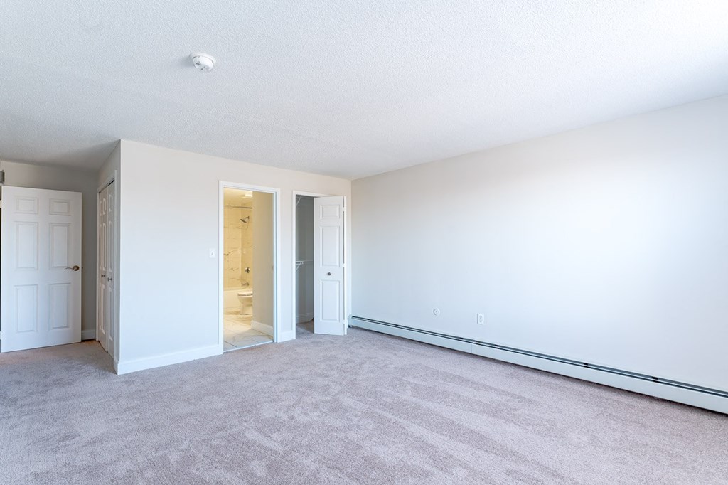 a bedroom with white walls and carpet