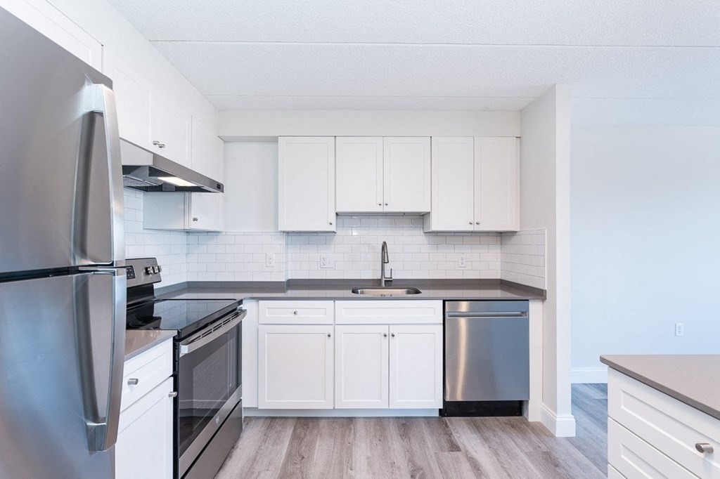 a kitchen with white cabinets and stainless steel appliances