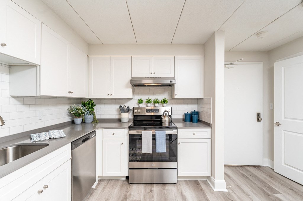 a kitchen with white cabinets and stainless steel appliances
