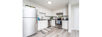 a kitchen with white cabinets and stainless steel appliances