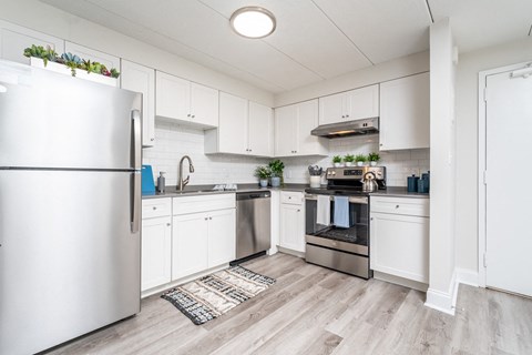 an open kitchen with stainless steel appliances and white cabinets