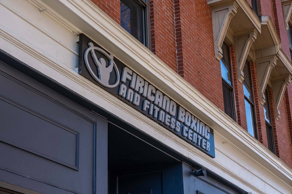 A sign for a Fireman's Fitness Boxing Center is displayed above a door.