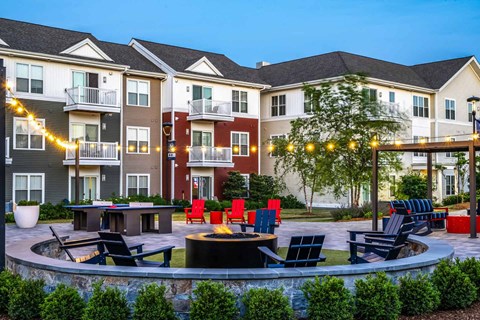 A residential area with apartment buildings and a fire pit in the foreground.