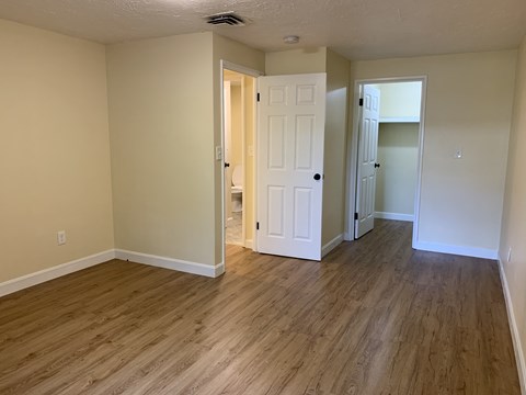a living room with wooden floors and a white door