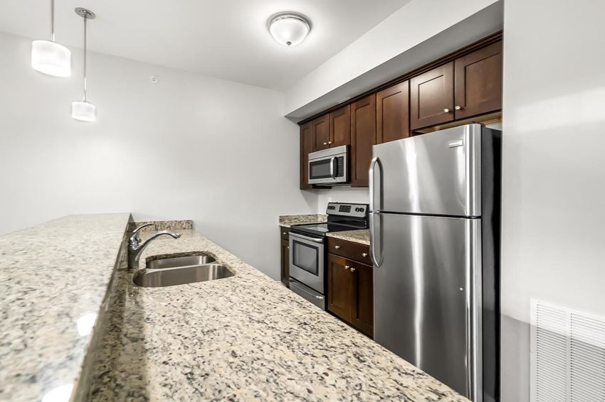 Ashland woods apartment kitchen with stainless steel appliances, stove, microwave, oven, and granite counters