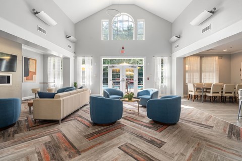 A spacious waiting room with blue chairs and a large window.