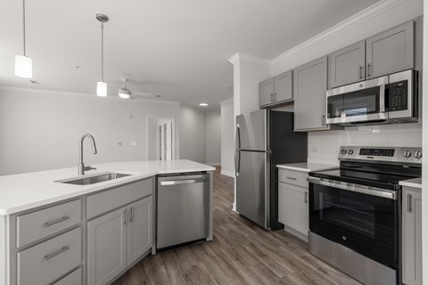 A modern kitchen with stainless steel appliances and wooden floors.