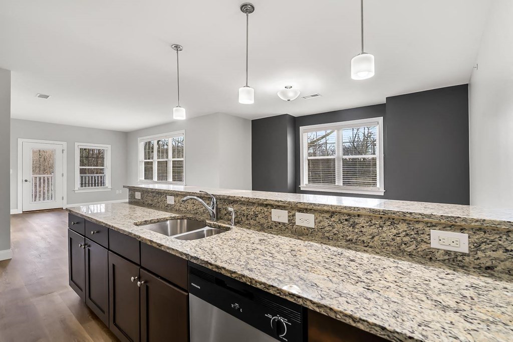 Ashland woods apartment kitchen with stainless steel appliances, stove, microwave, oven, and granite counters. Accent wall in background