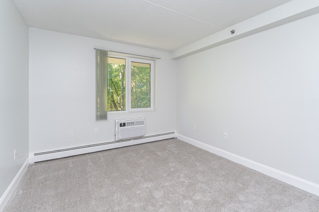 an empty living room with white walls and a window