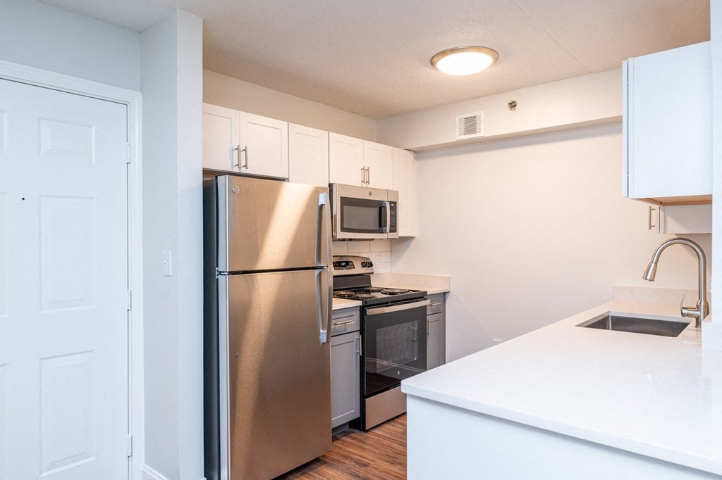 a renovated kitchen with stainless steel appliances and white cabinets