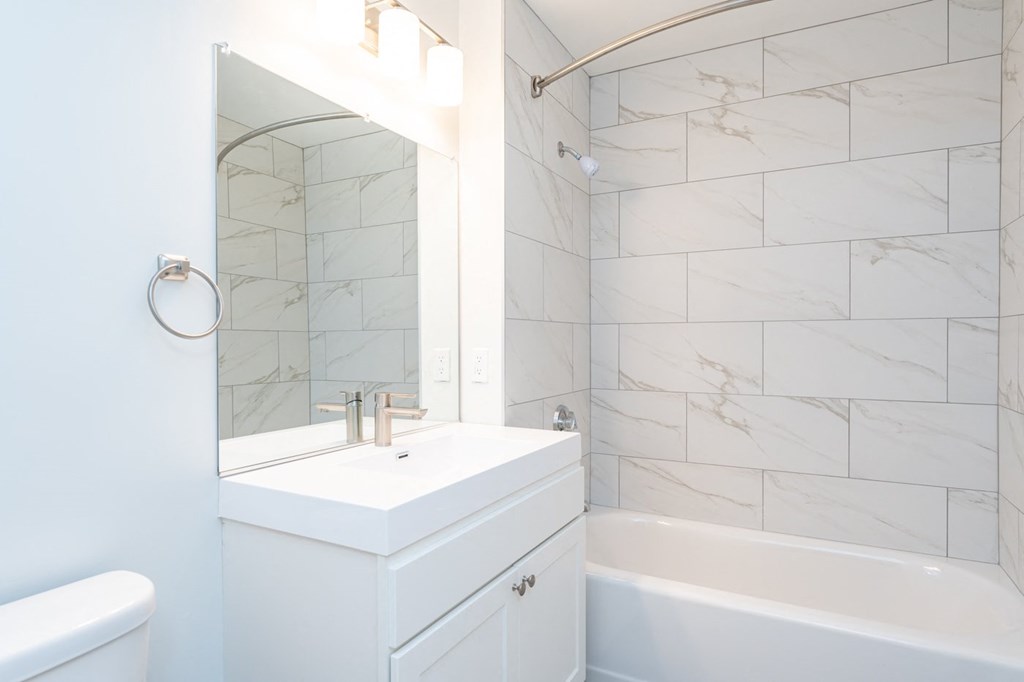 a white bathroom with a sink and a mirror