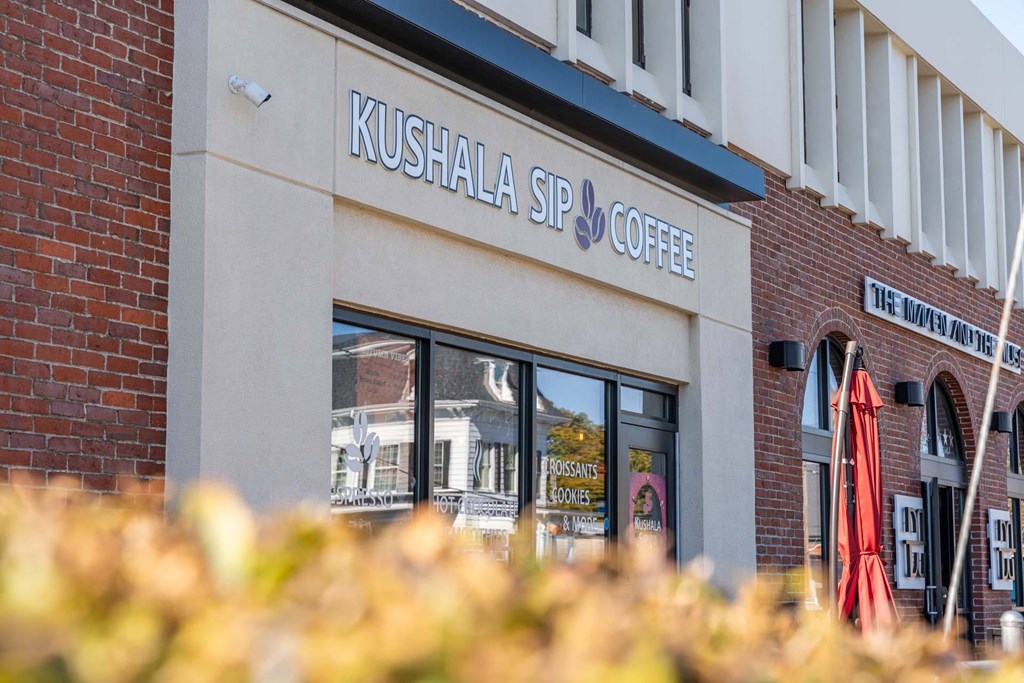 A brick building with a sign that says Kushala Sip Coffee.
