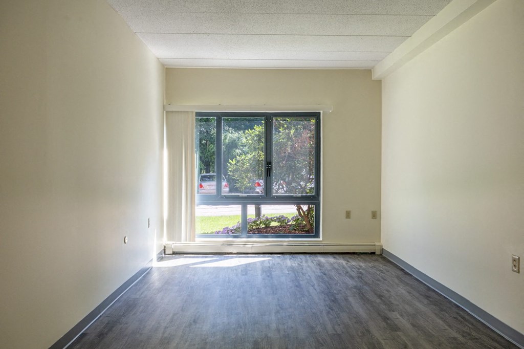 the living room of an empty apartment with a large window