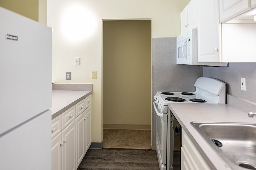 an empty kitchen with white cabinets and a white stove and refrigerator, apartment intererior