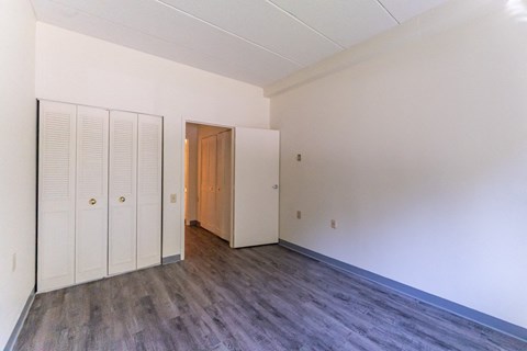 an empty bedroom of lincoln school room with white walls and wood flooring