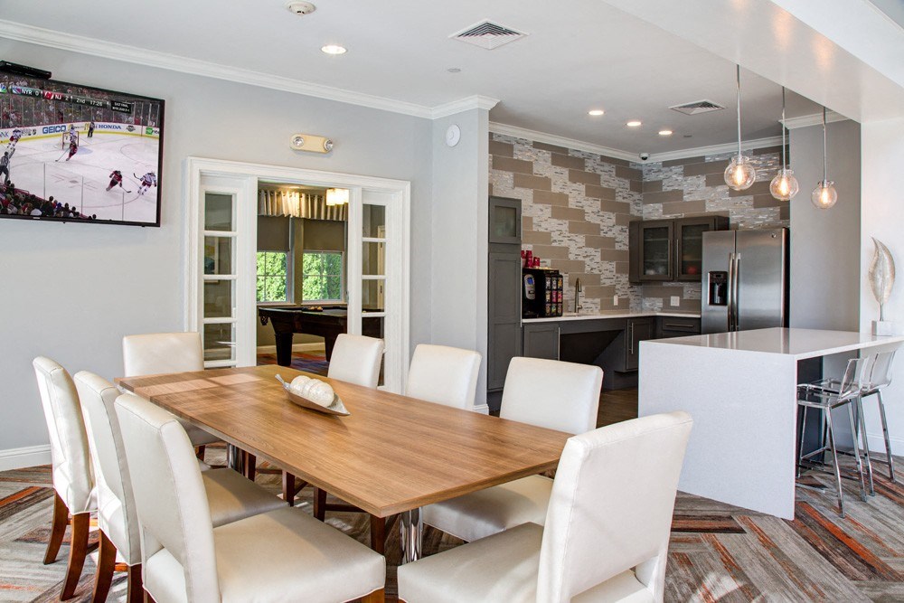A modern dining room with a wooden table and white chairs.