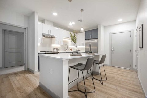 an open kitchen and dining area with a white counter top