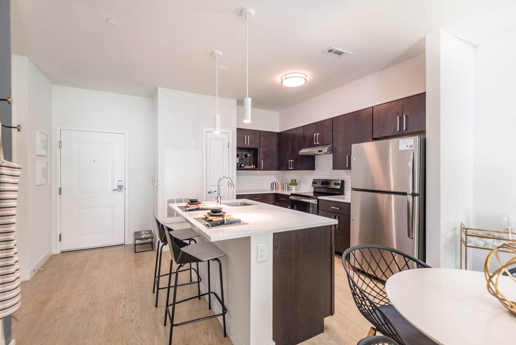 a kitchen with a large center island with a breakfast bar