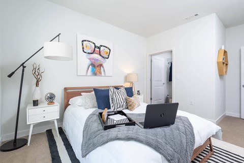 a bedroom with a bed with a laptop on it