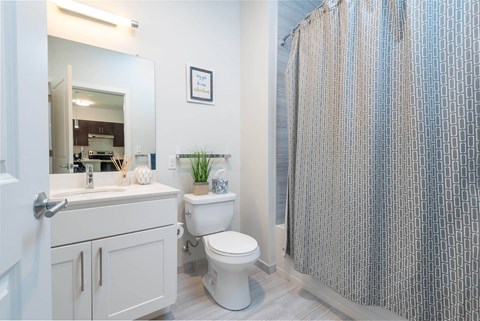 a bathroom with a shower and a toilet next to a sink