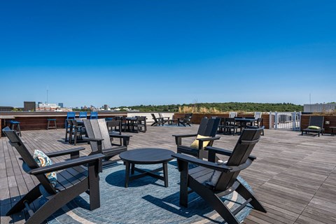 a roof deck with tables and chairs on top of a building