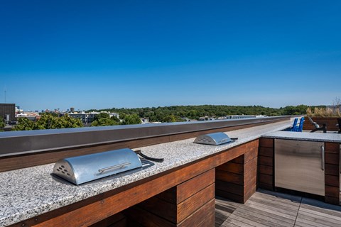 a rooftop terrace with a table with two microwaves on it