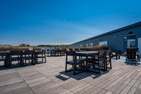 a patio with tables and chairs on a roof