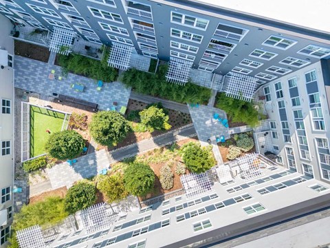 an aerial view of an apartment building with a green courtyard
