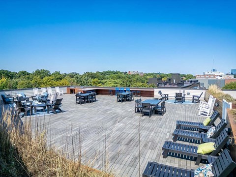 the deck on the top of the building has tables and chairs