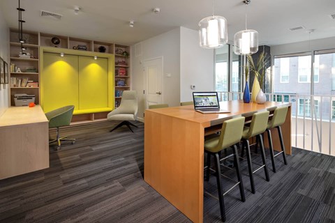 a room with a table and chairs with a laptop on it