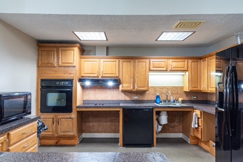 A kitchen with wooden cabinets and black appliances.